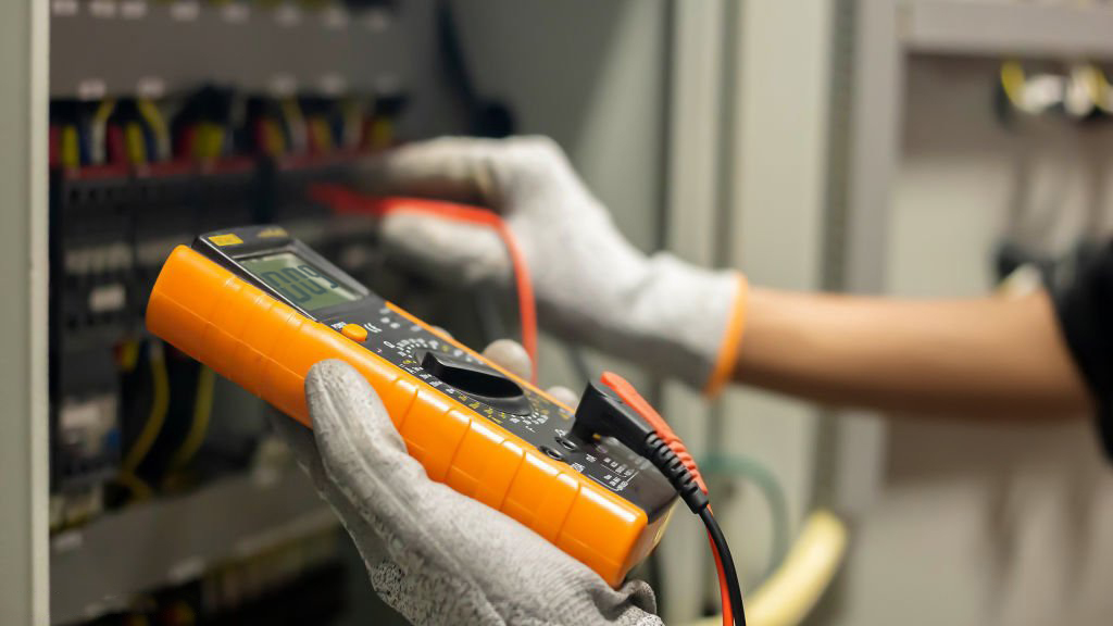 Eletricista trabalhando em um painel elétrico em Cruz Alta